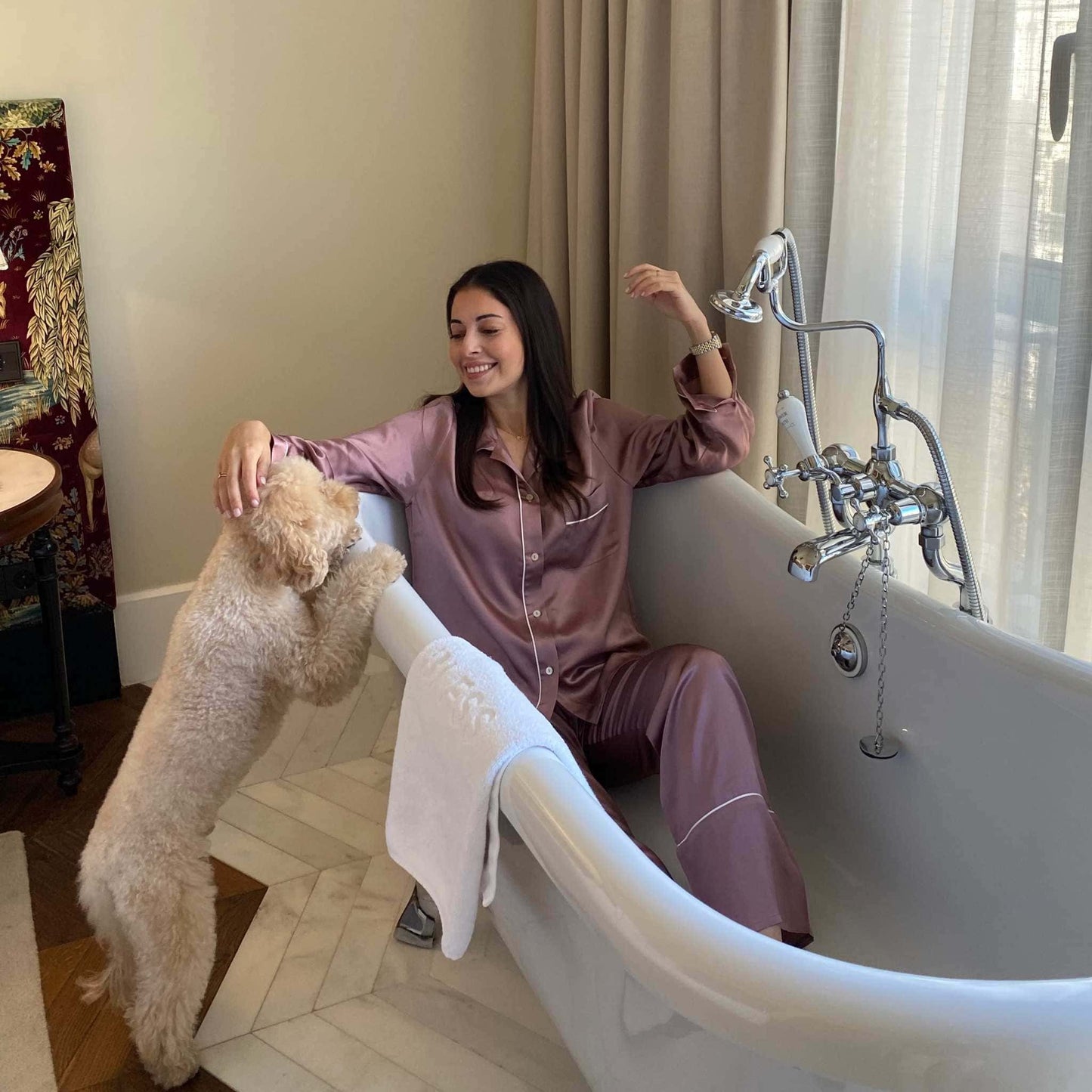 chica en la bañera con el pijama de seda rosa de Herriet acariciando a un caniche