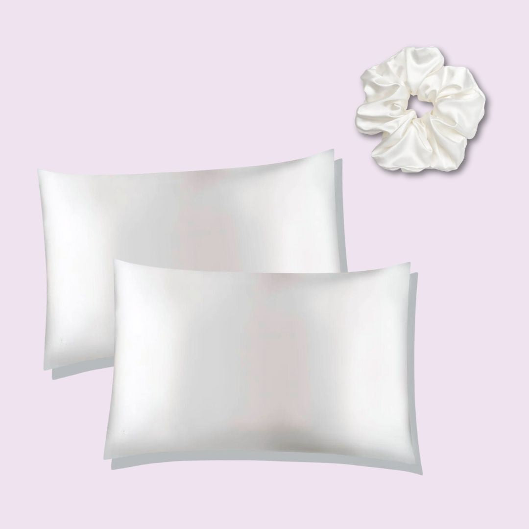 Two silk pillowcases and a silk scrunchie on a light purple background (herriet)