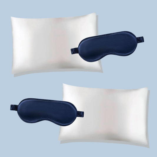Two white silk pillowcases with navy blue sleep masks on a light blue background
