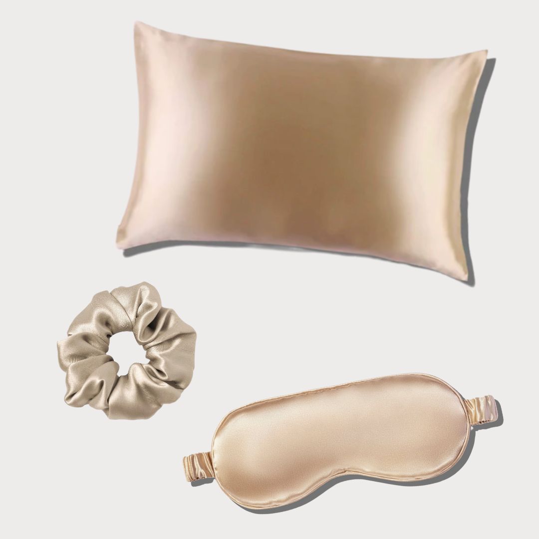 Set of silk pillowcase, silk scrunchie, and silk sleep eye mask on a light gray background from Herriet