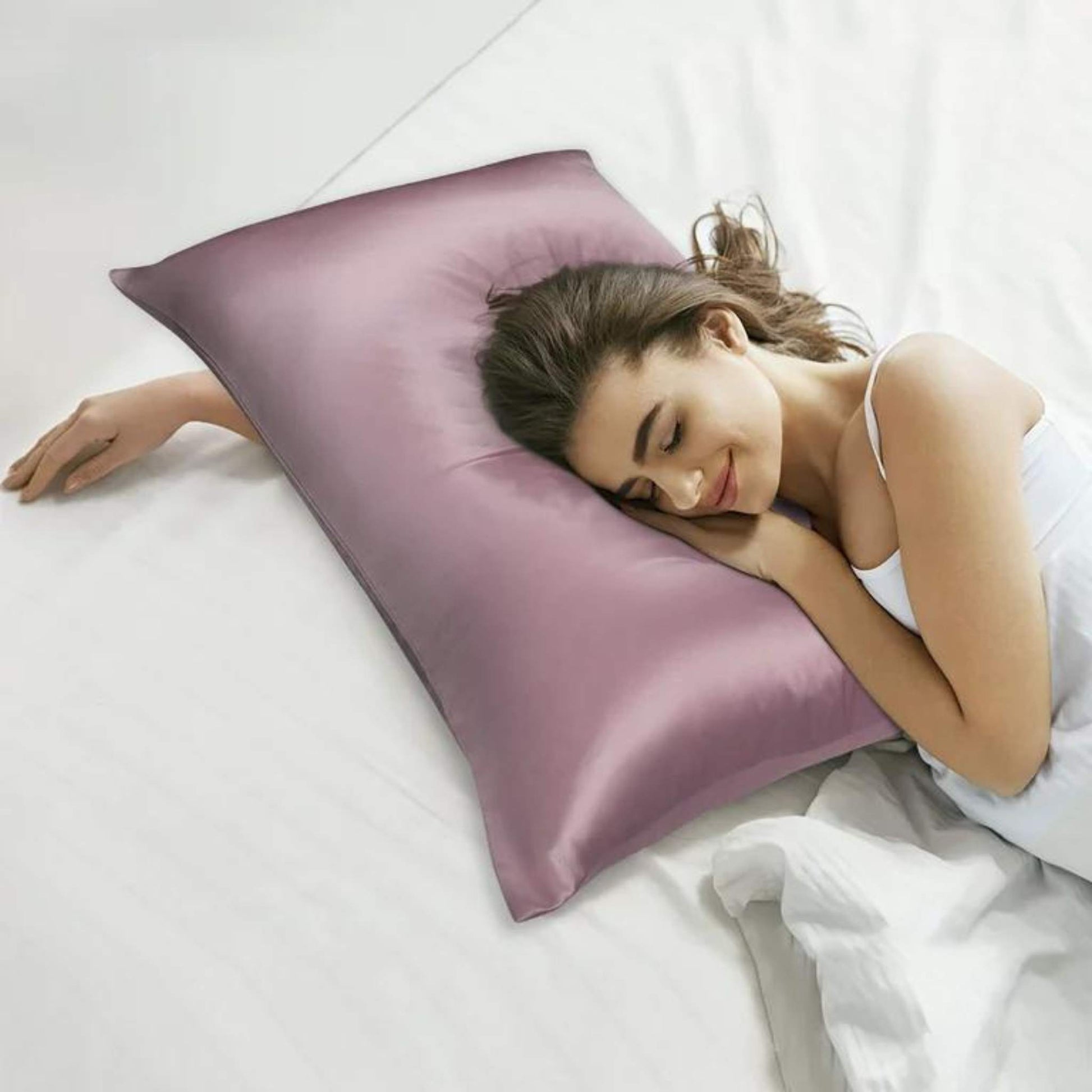 chica en cama con la cabeza apoyada en una funda de almohada de seda en color rosa - herriet